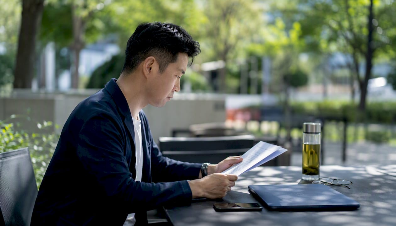 Man reviewing commercial lease types at café