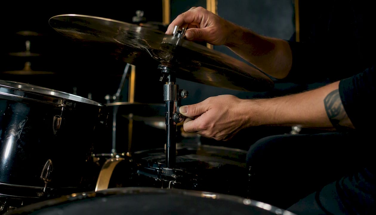 Hands adjusting cymbal angle and stand hardware