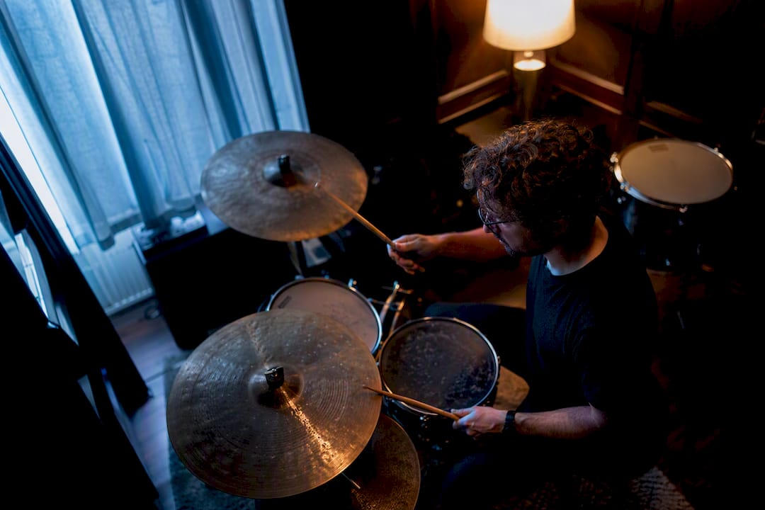 Drummer playing soft low-volume cymbals indoors