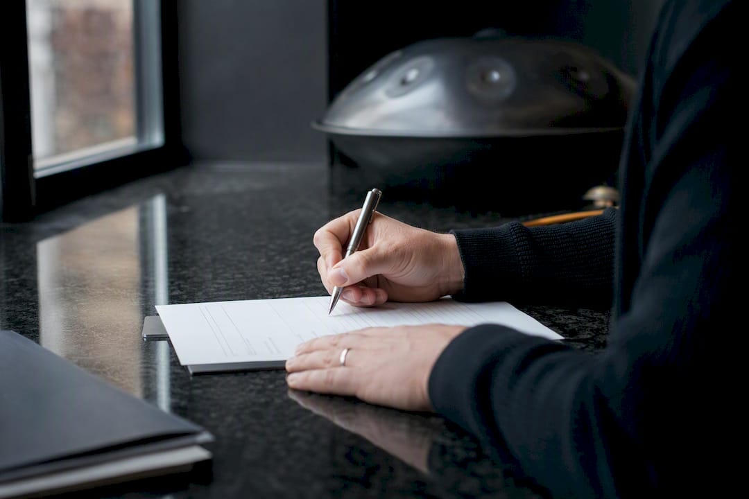 Hands filling out application form on clipboard
