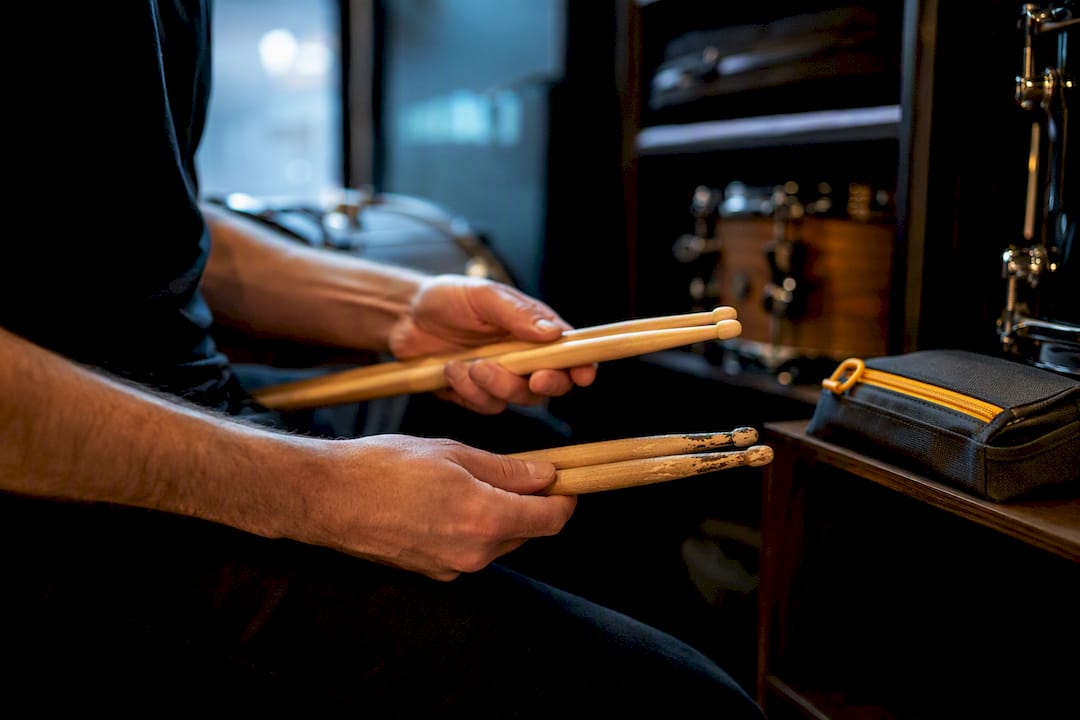 Drummer comparing worn and fresh stick ends