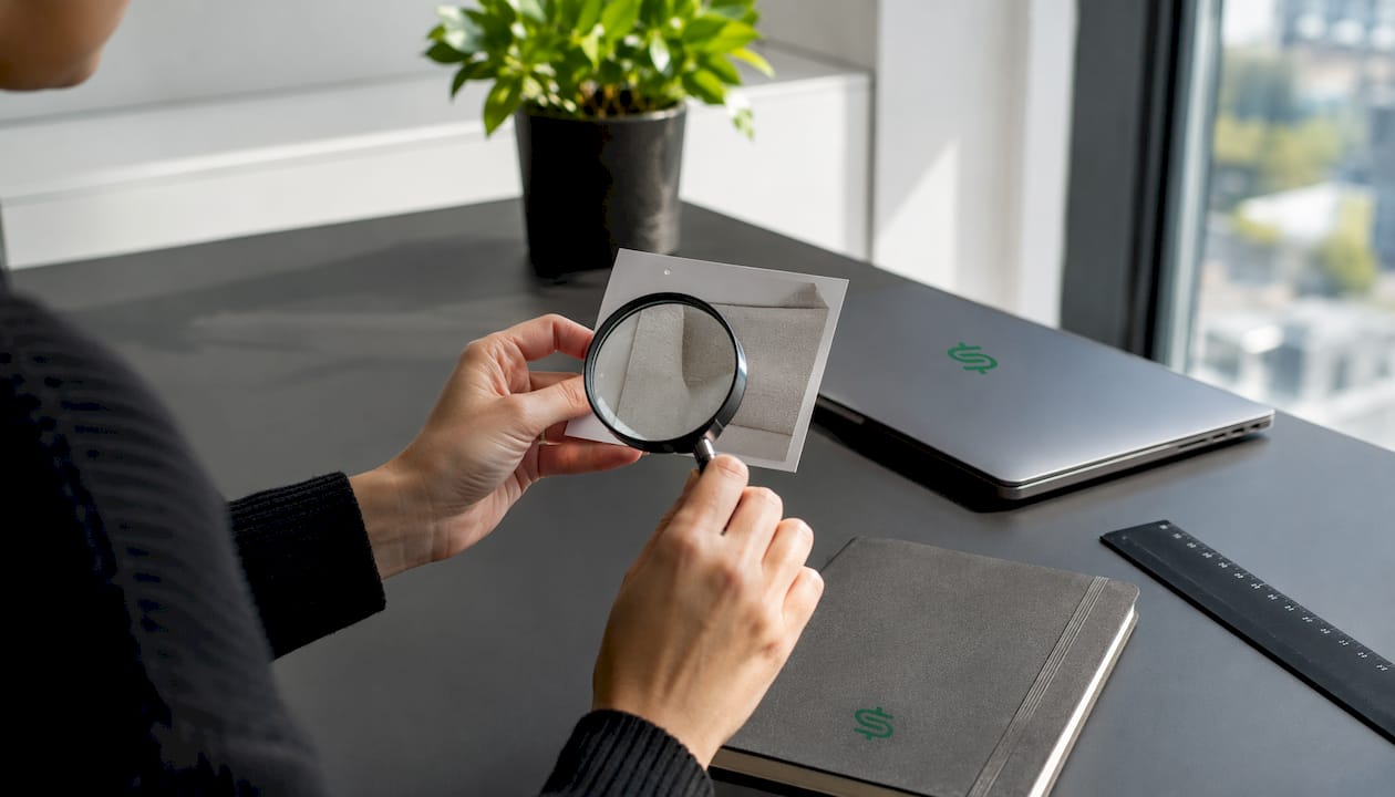 Hands inspecting product label details with magnifier