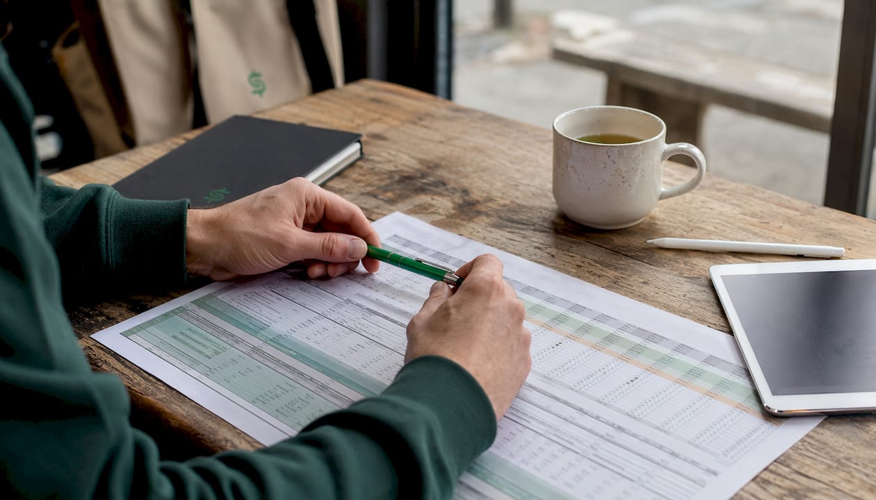 Overhead view of hands reviewing product spreadsheets