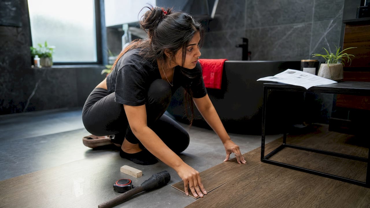 Woman installing luxury vinyl plank flooring