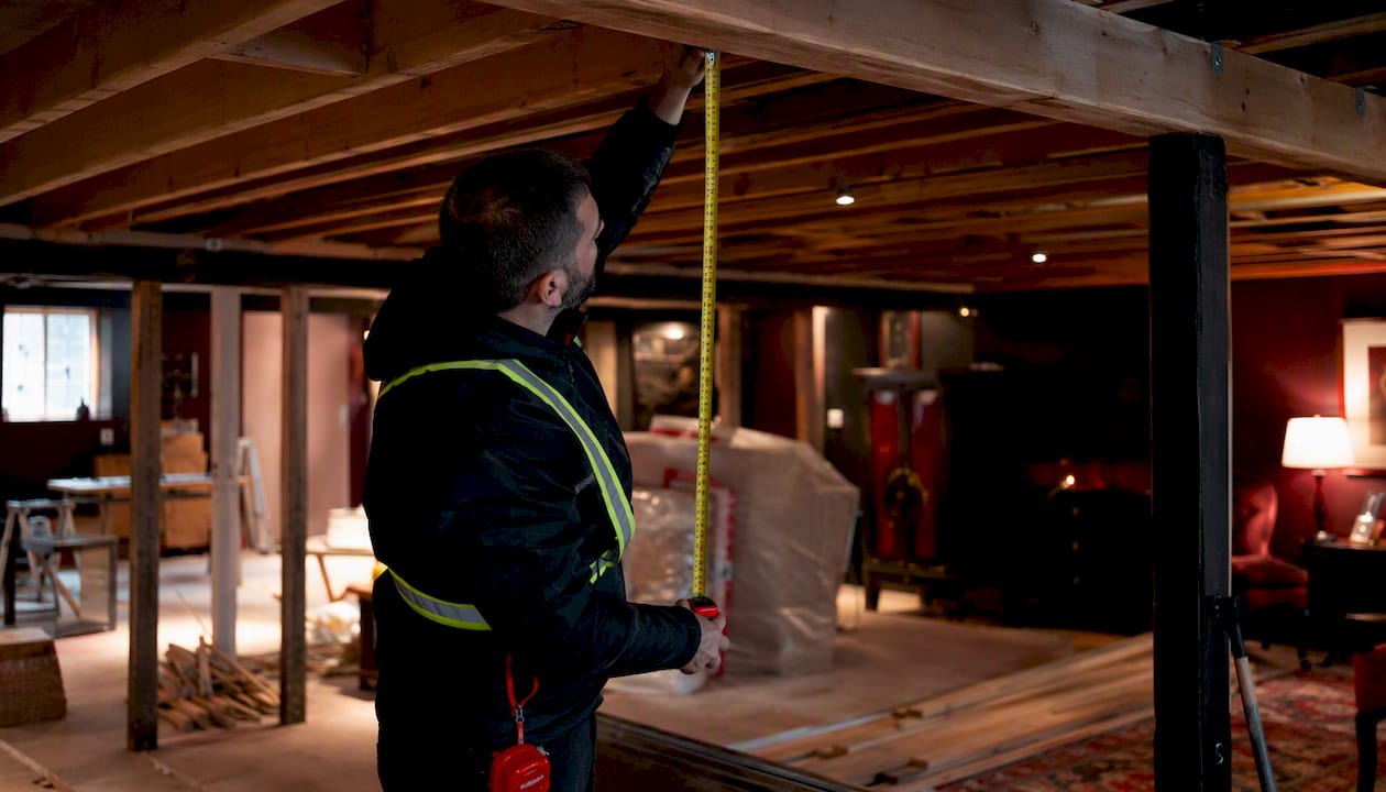 Building inspector measuring basement ceiling height