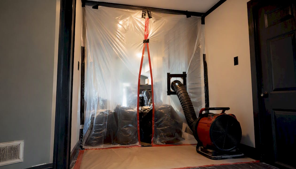 Plastic sheeting sealed work area for drywall removal