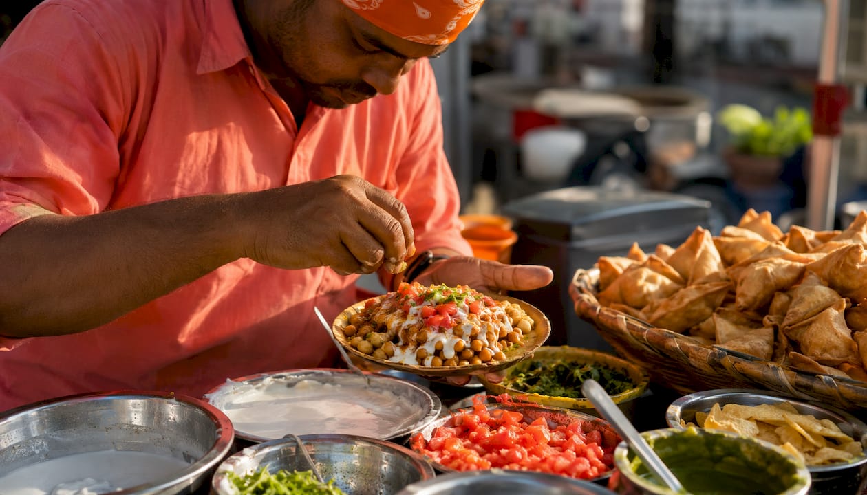 Close-up of hands preparing Indian chaat dish