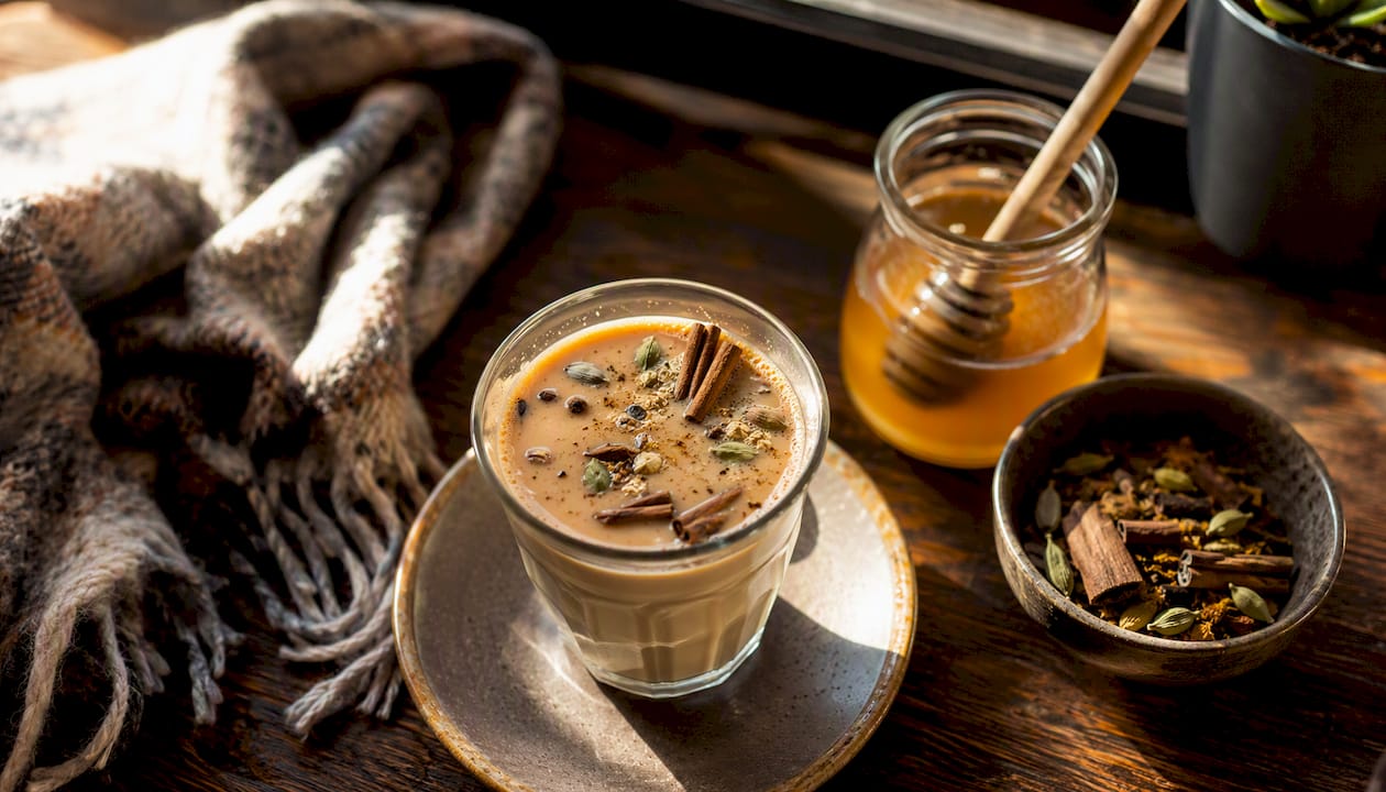 Winter spiced chai with fresh spices on cafe table