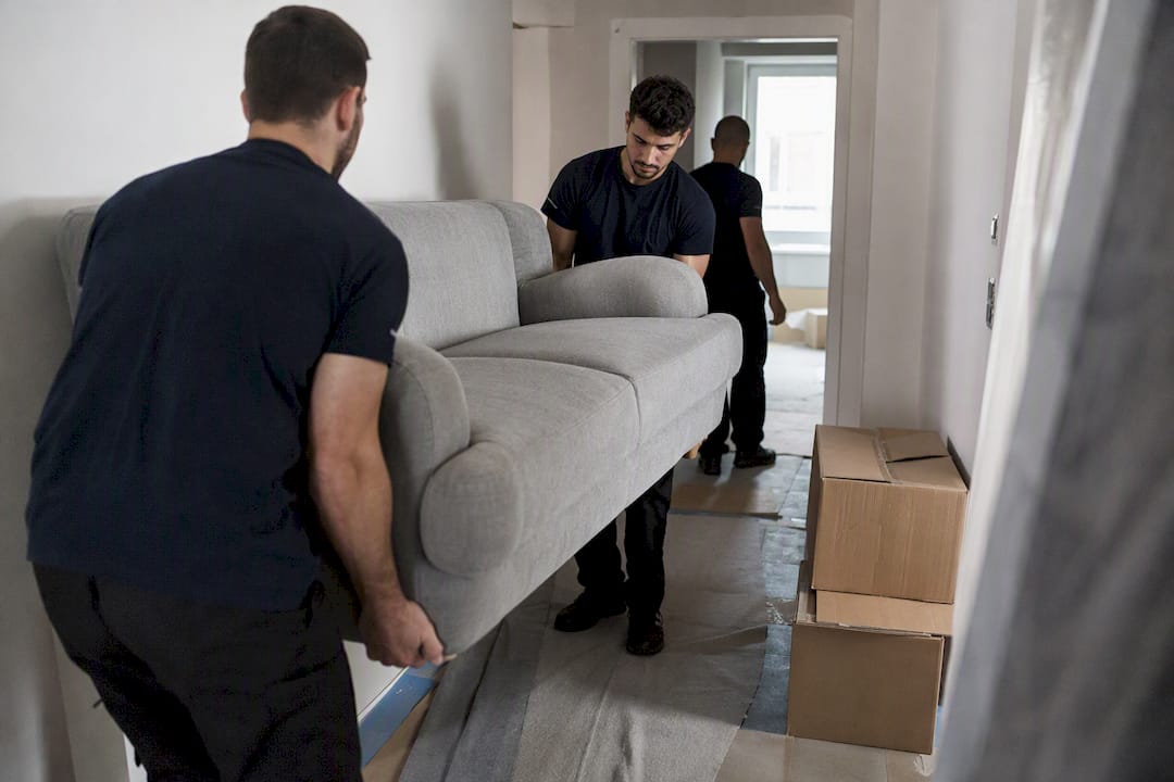 Déménageurs descendant un canapé dans l'escalier