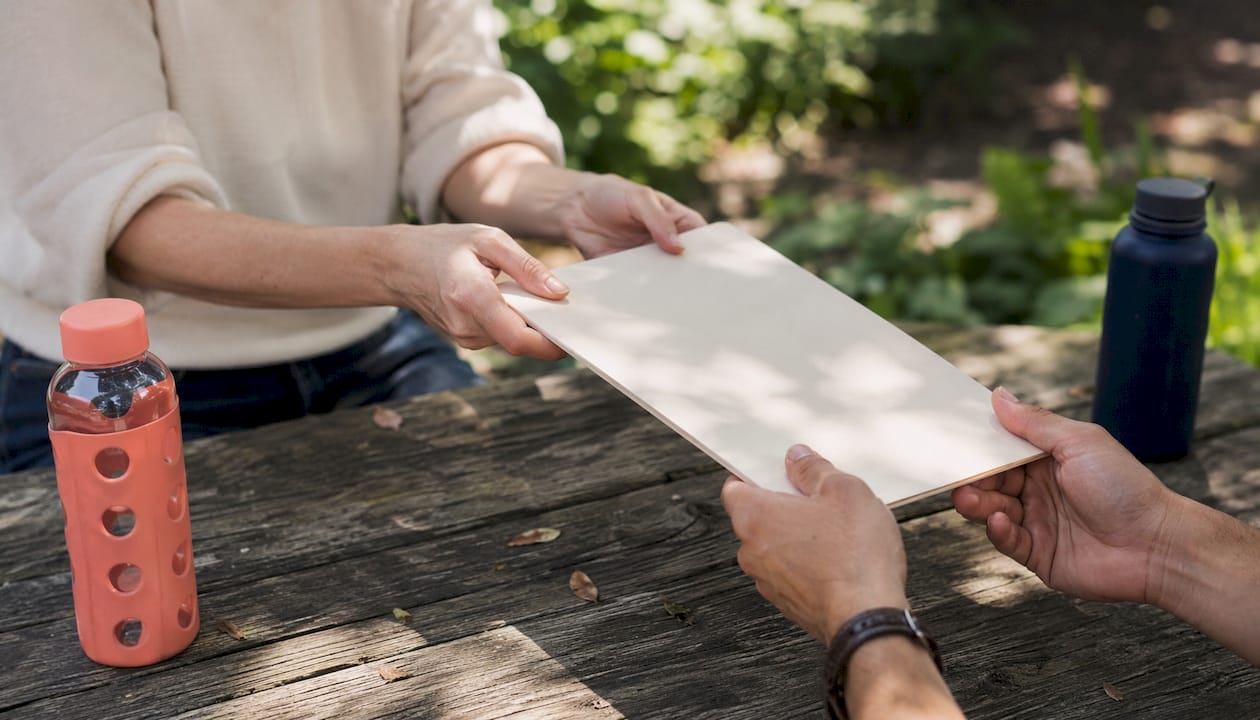 Hands exchanging small employer leave documents