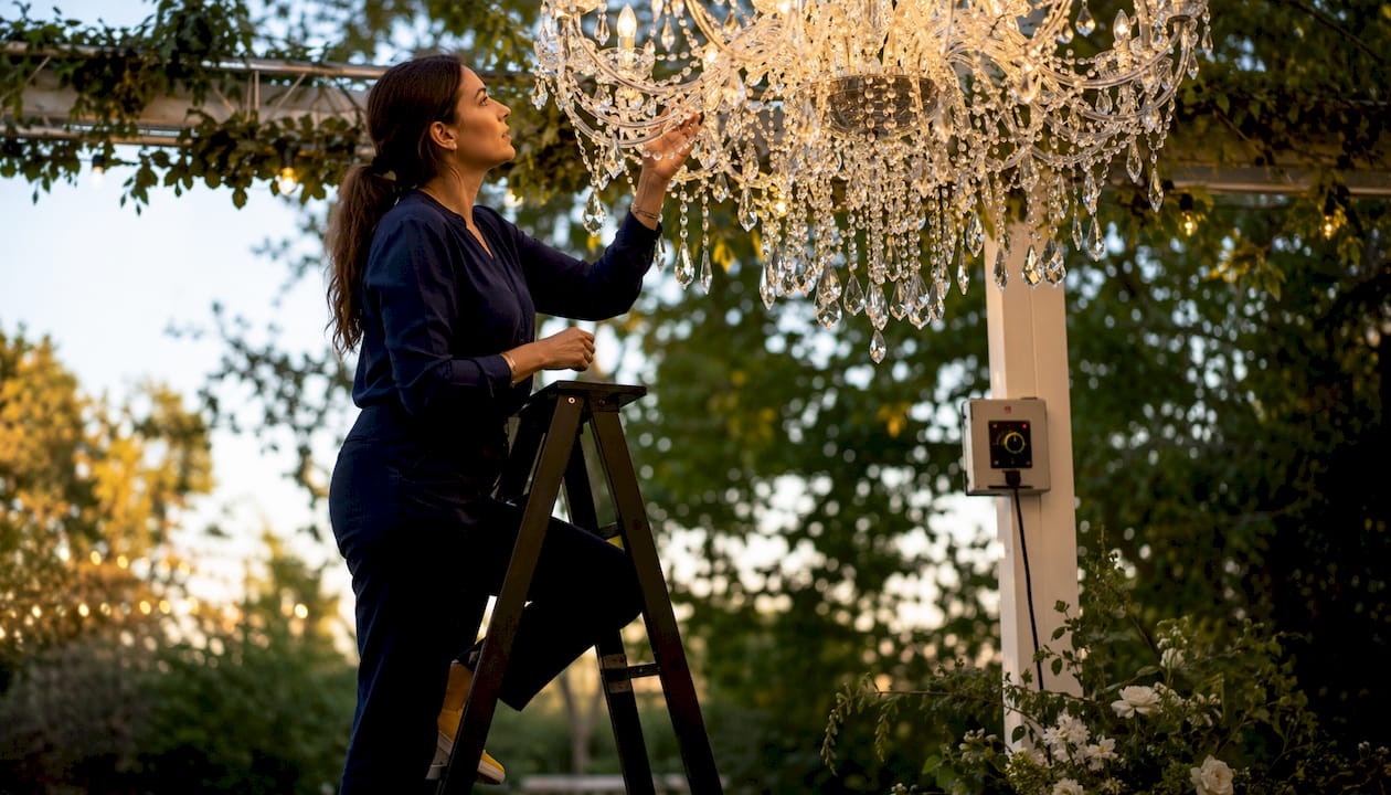 Decorator adjusting lighting on chandelier