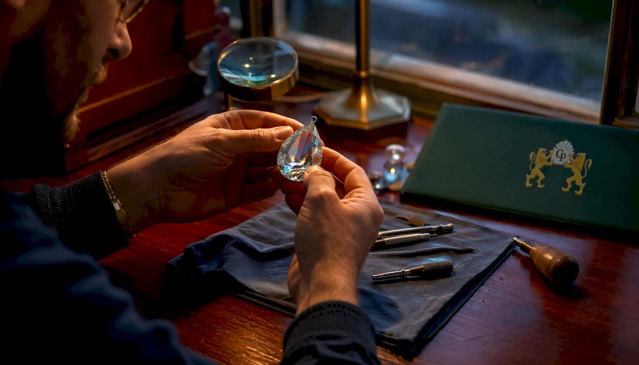 Hands inspecting teardrop crystal clarity