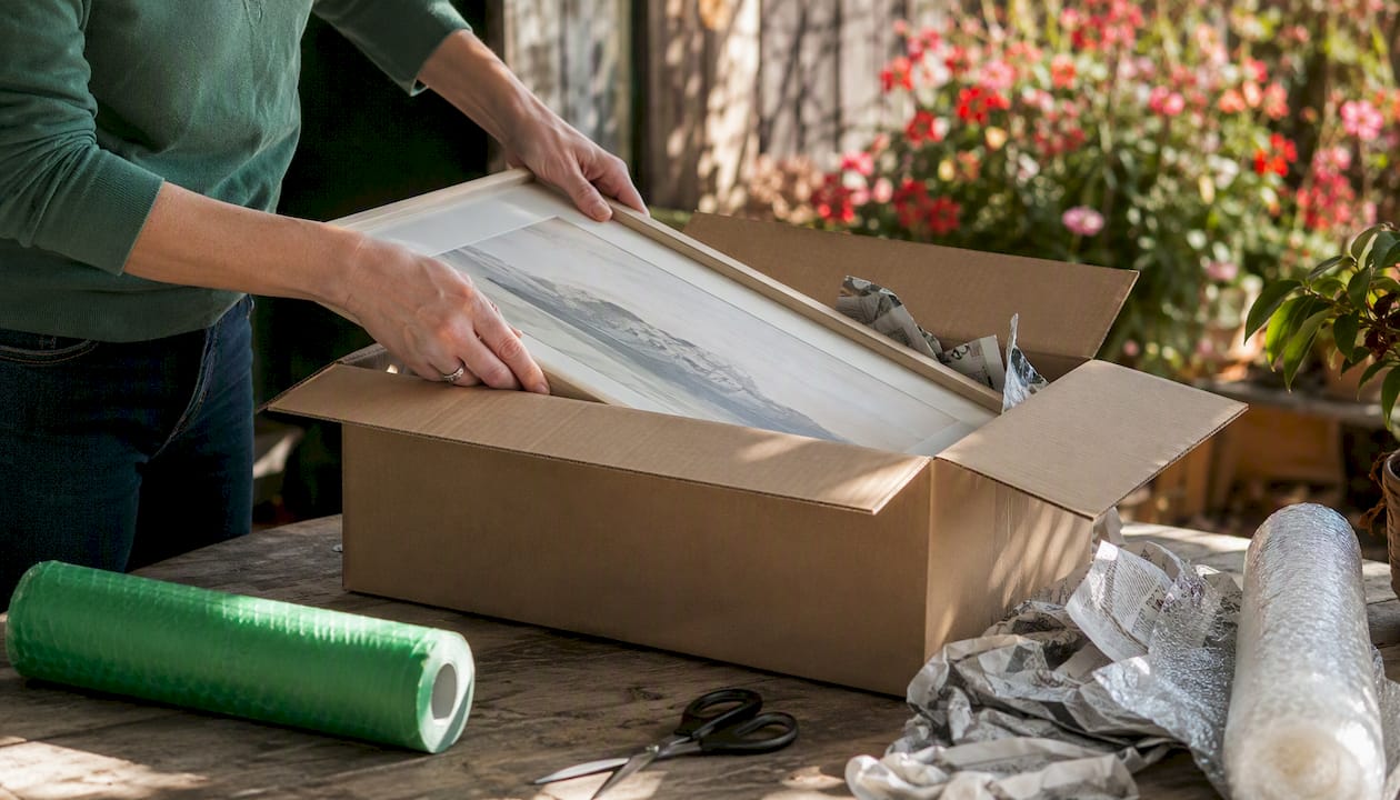 Hands wrapping artwork for local sale pickup