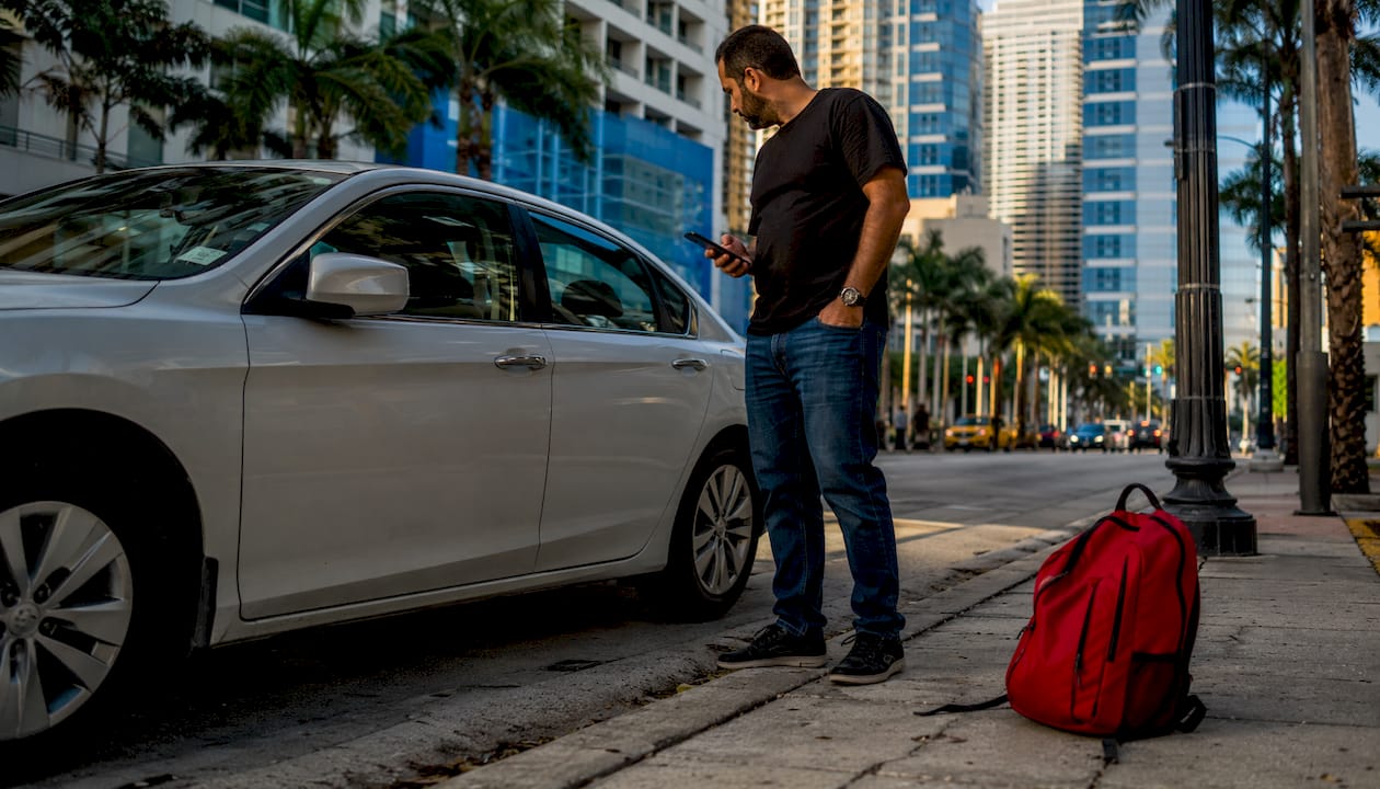 Man calling roadside assistance beside locked car