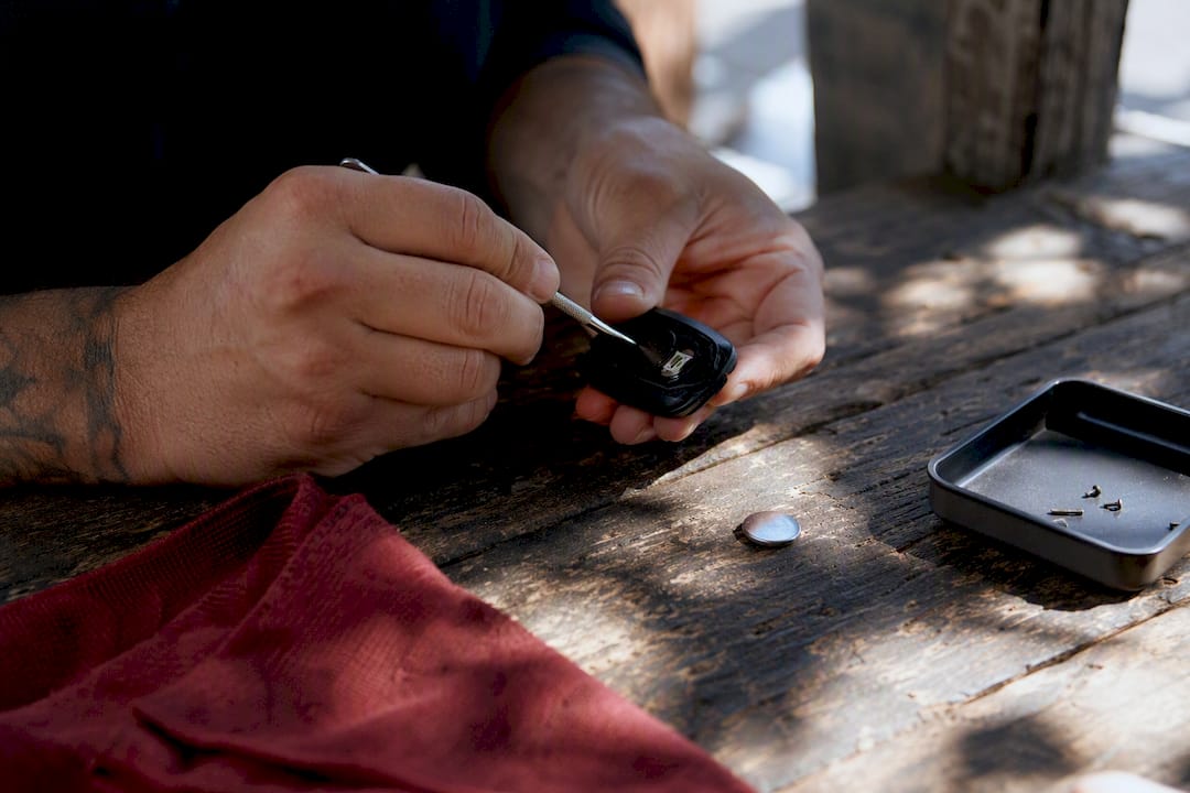 Hands opening a car key fob to replace battery