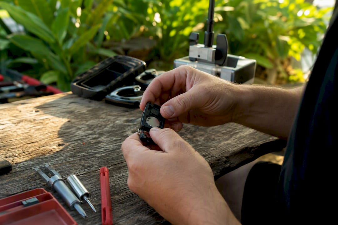 Hands replacing car key fob battery