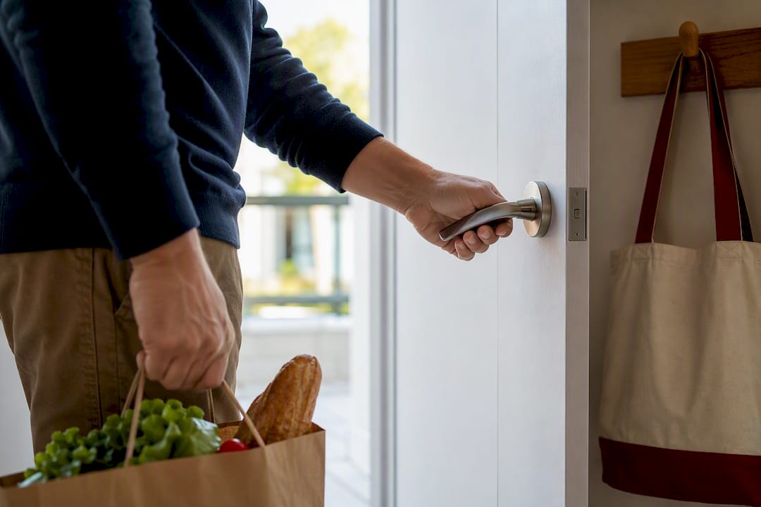 Hand pressing lever while carrying groceries