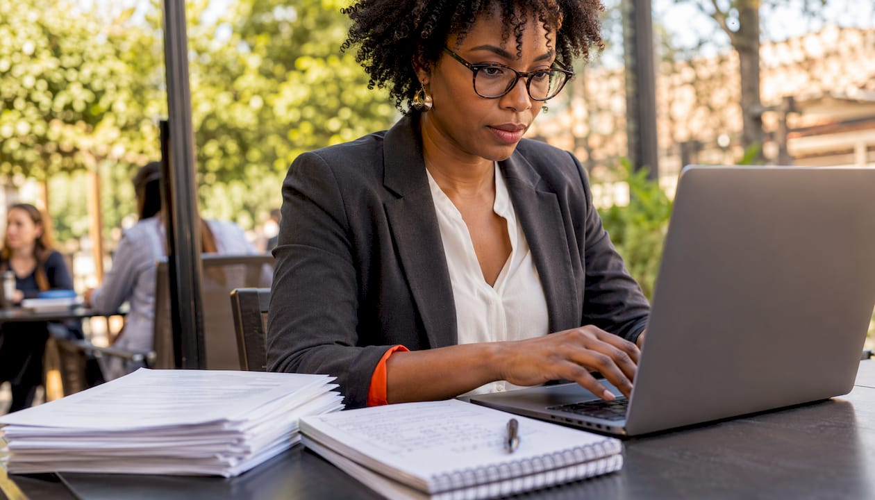 Professional woman editing resume skills on laptop