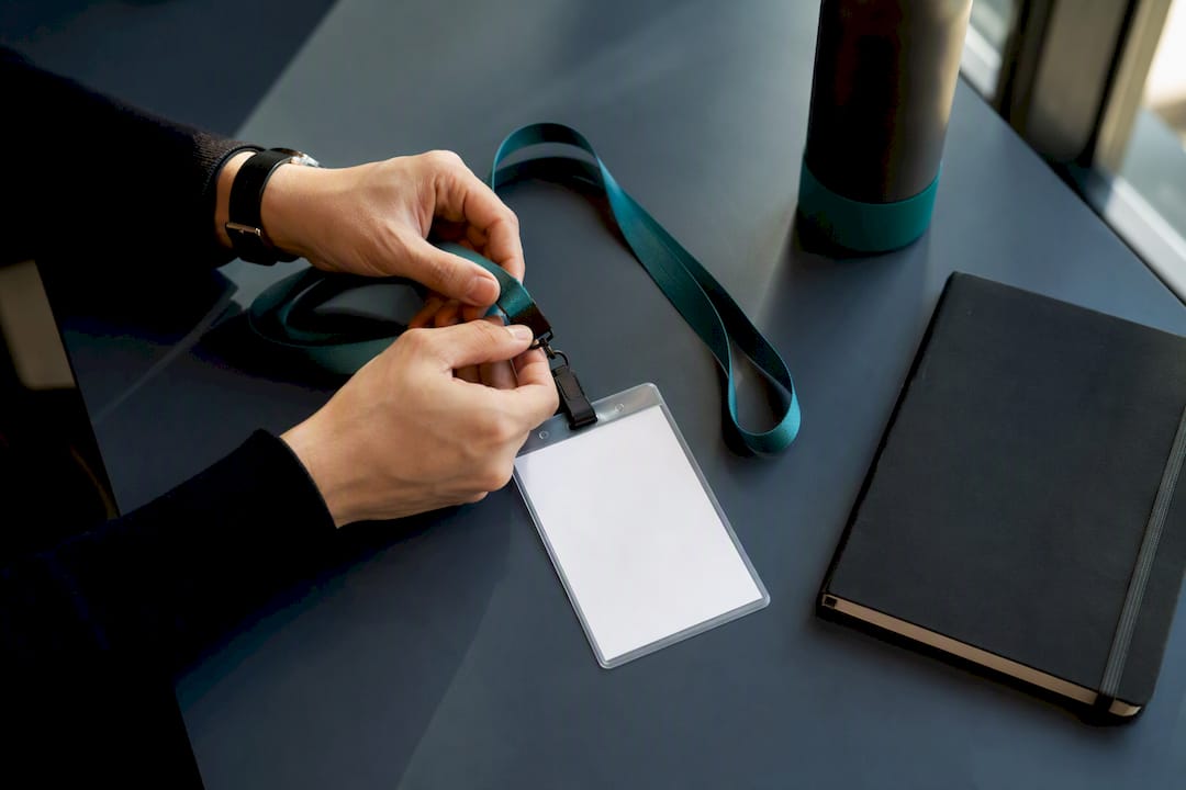 Hands adjusting startup event badge lanyard