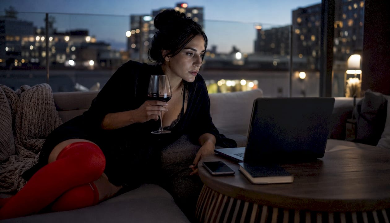 Woman browsing femdom marketplace on laptop