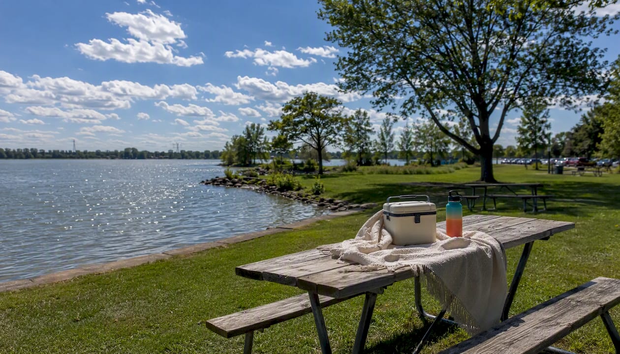 Picnic tables by lake shore in Oakville