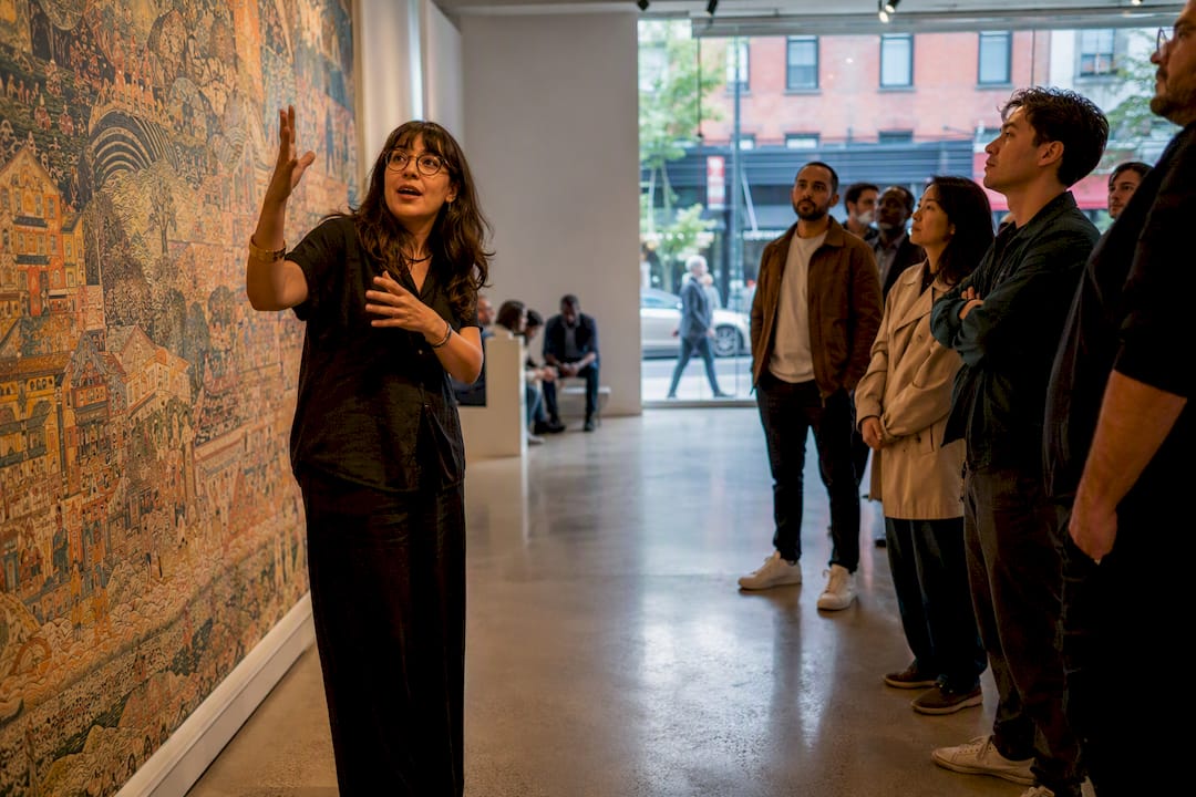 Curator pointing at artwork during guided gallery tour