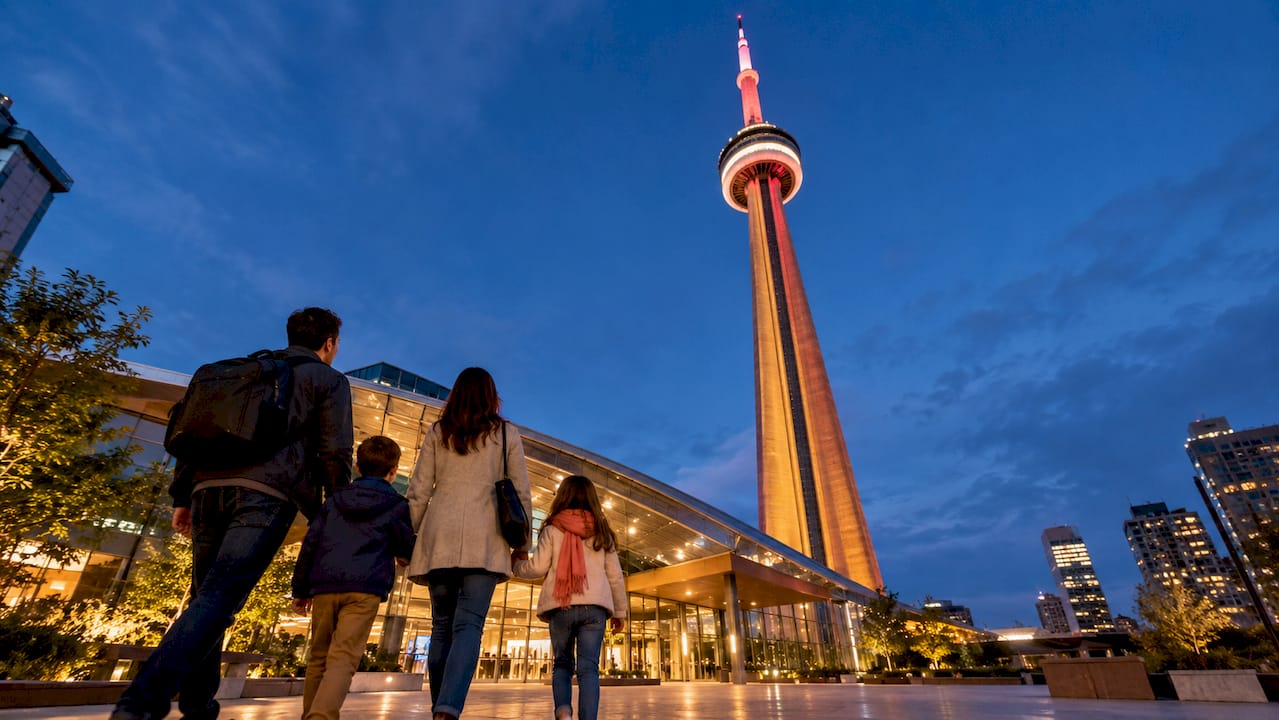Family approaching Toronto tower at night