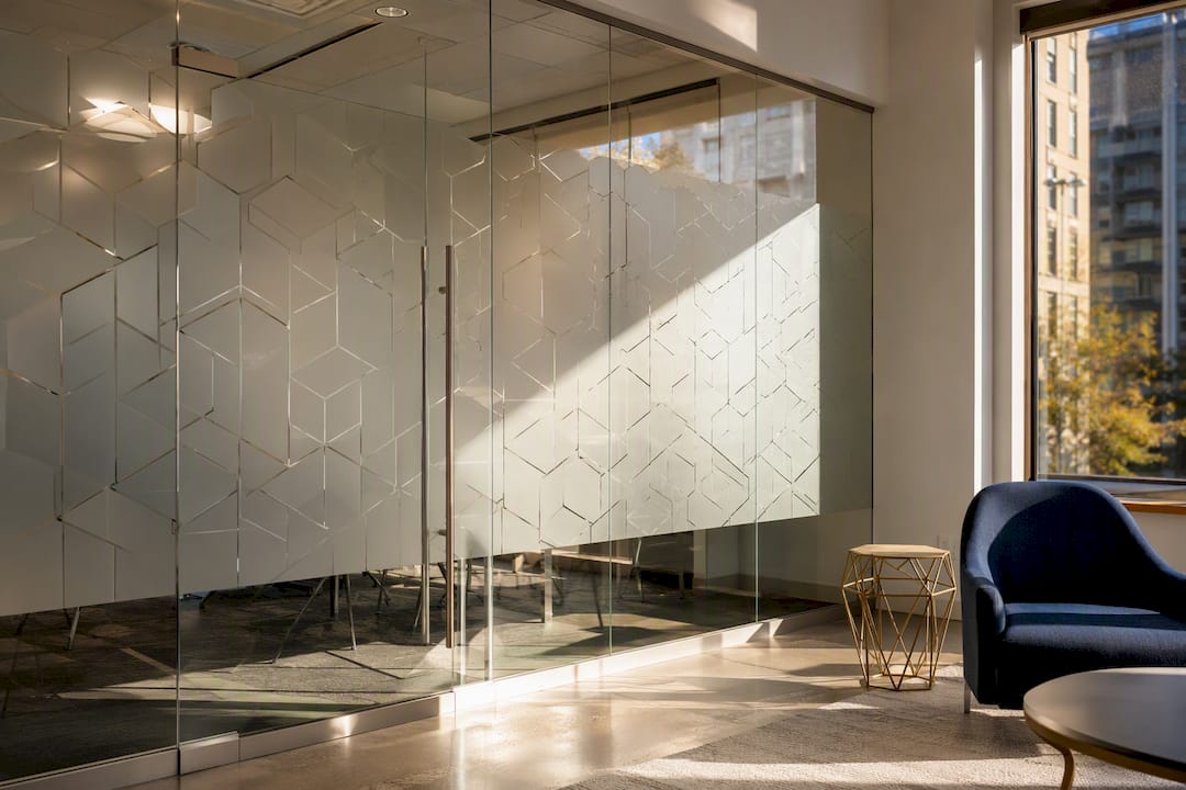 Glass partition with decorative privacy film in office