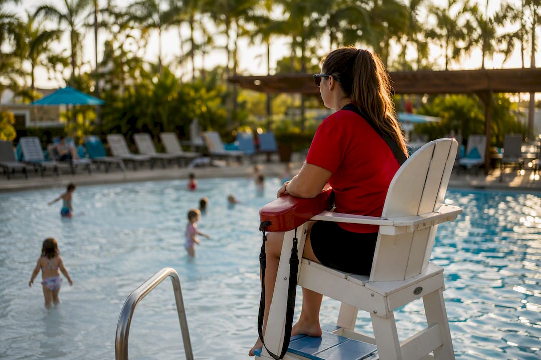 Hotel pool lifeguard overseeing shallow child area