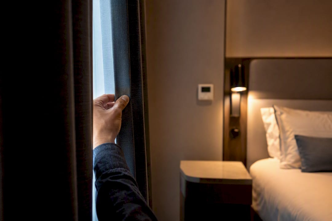 Traveler checking hotel blackout curtains