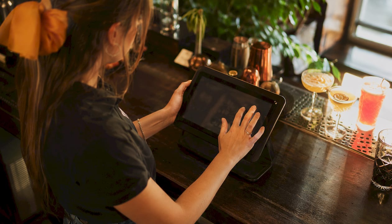 Bartender using POS terminal hands close-up