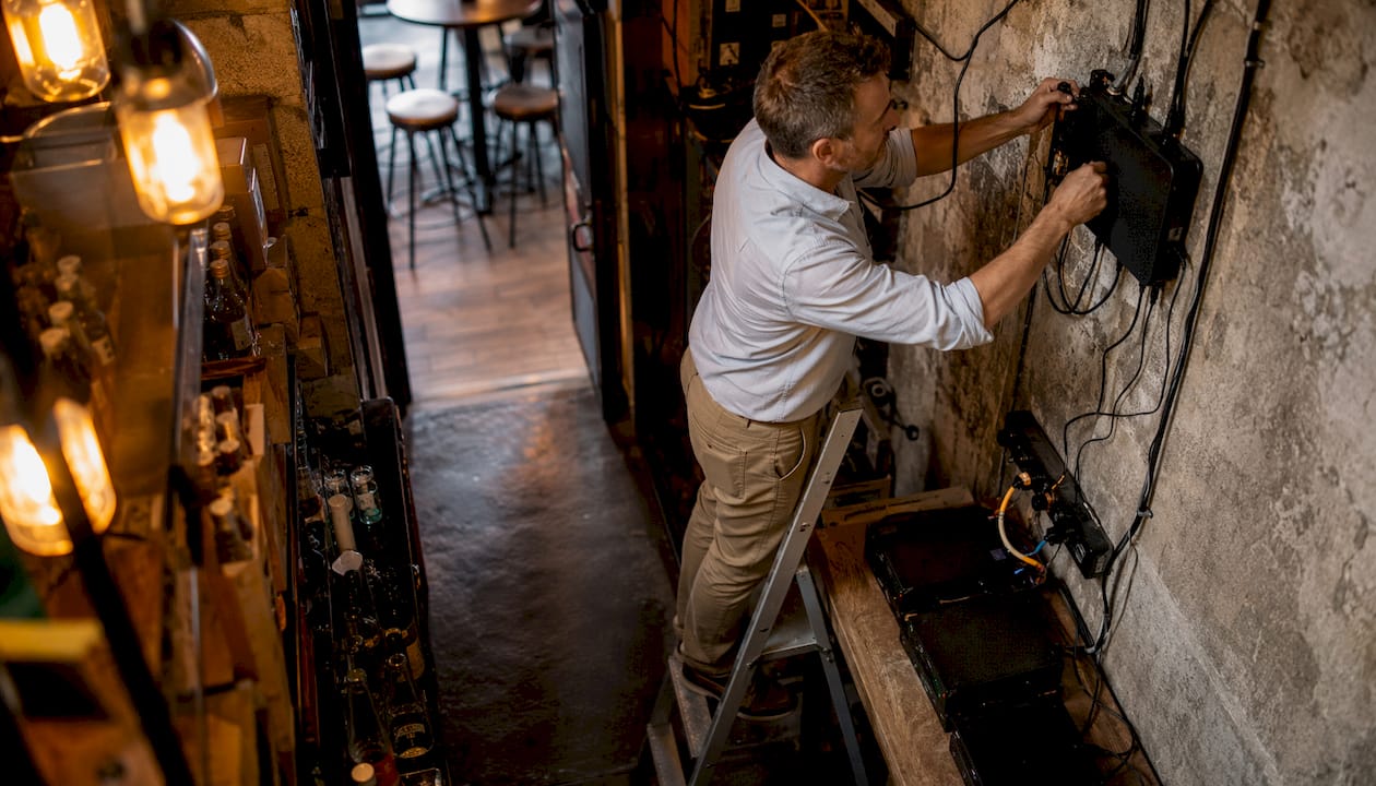 Technician setting up pub network hardware
