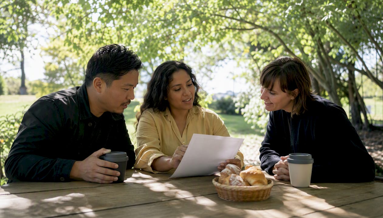Group discussing newsletter tools over coffee