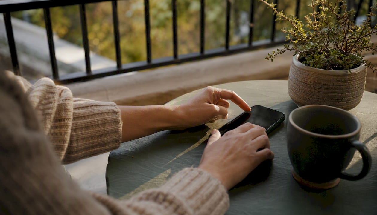 Hands typing on smartphone in coaching setup