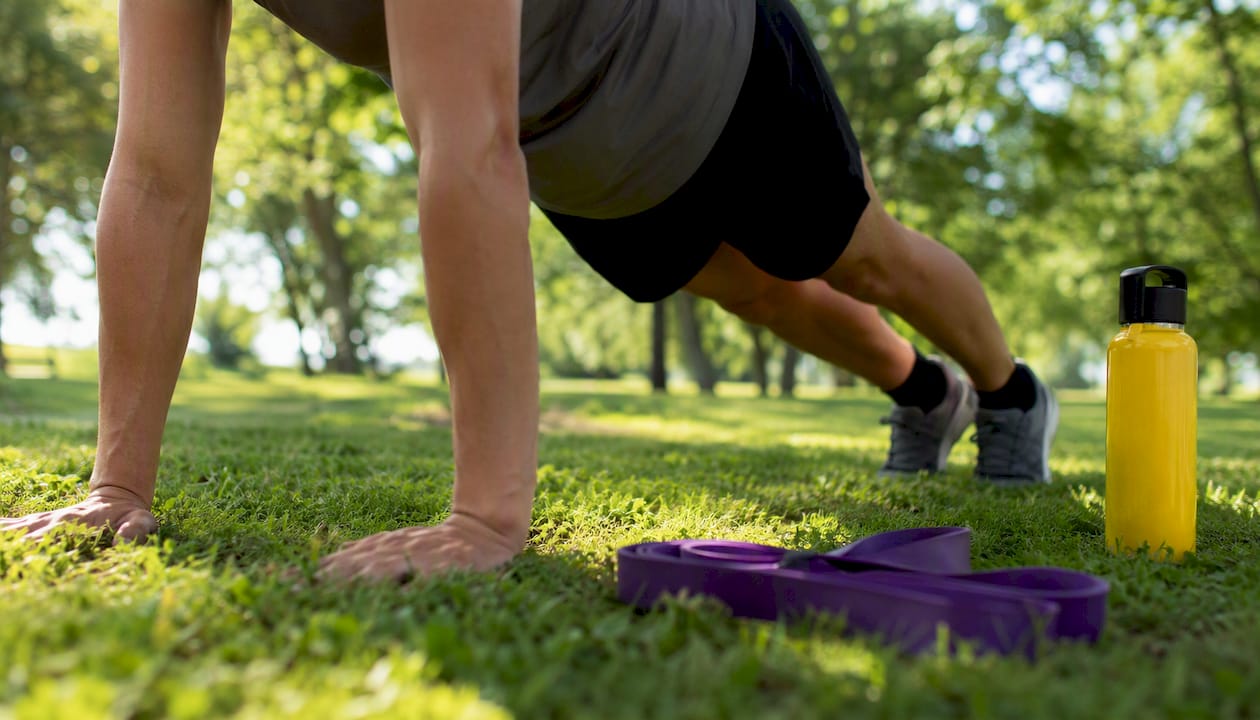 Hands and feet holding plank exercise on yoga mat