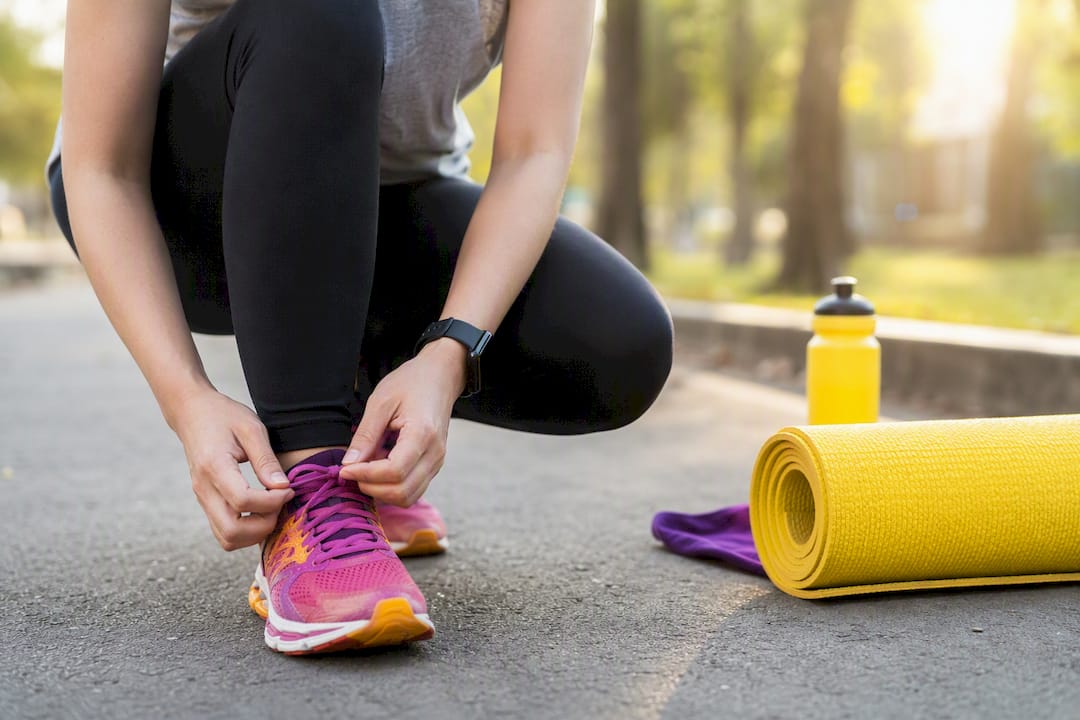 Person tying running shoes outdoors