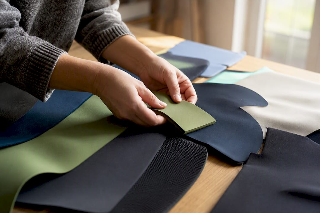 Mit den Händen verschiedene nachhaltige Neoprenmaterialien ertasten und die Unterschiede spüren.