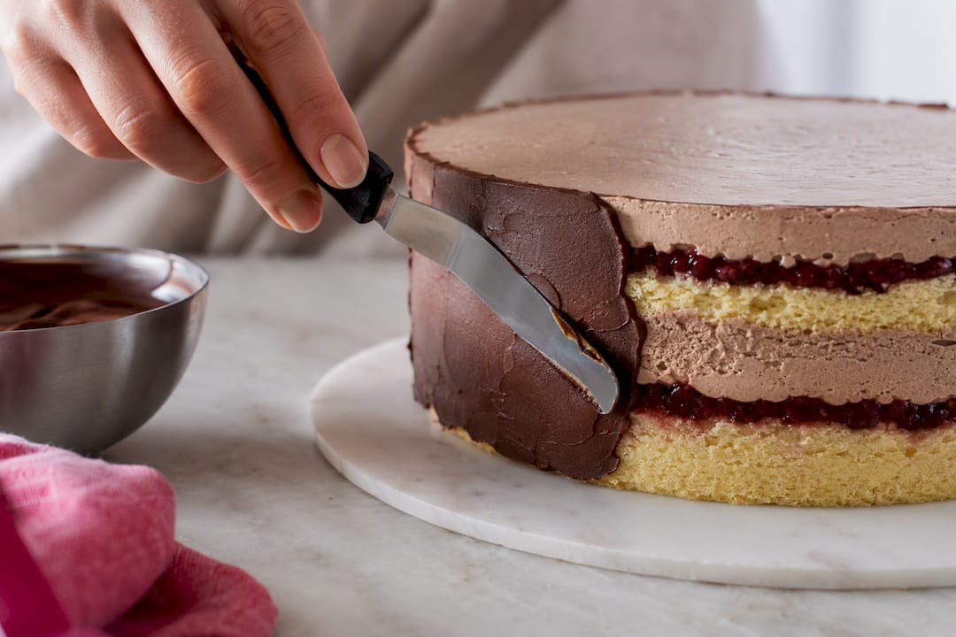 Ganache als Schutzschicht am Rand der Torte auftragen