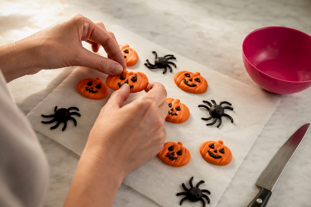 Hände fertigen kleine Fondantfiguren für Halloween an
