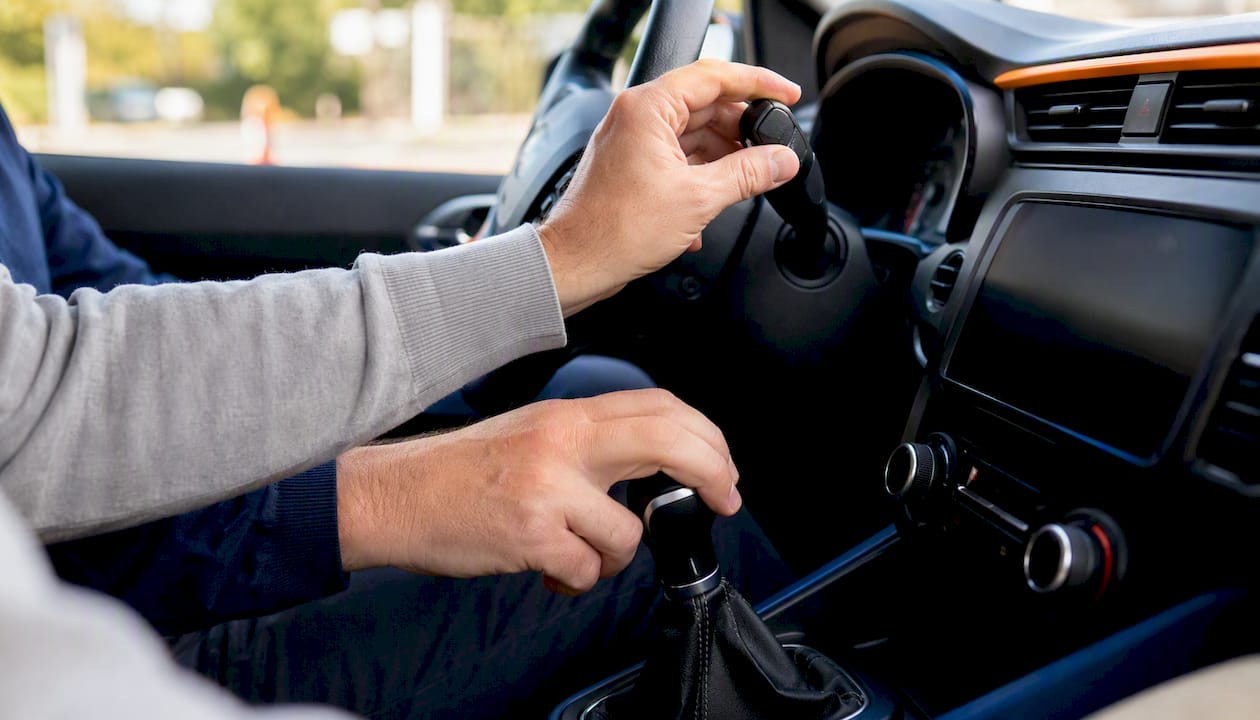 Les mains du moniteur expliquent le fonctionnement des commandes au volant.