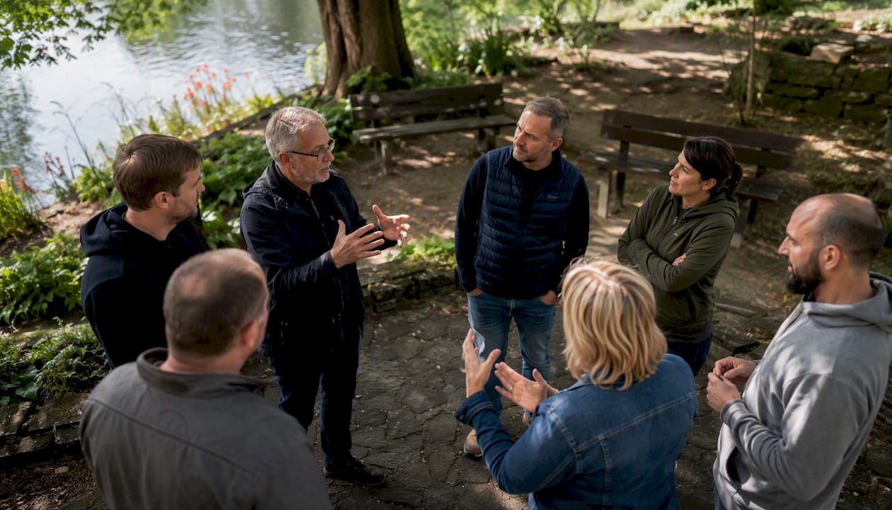 Des mains qui s’animent au rythme des échanges lors d’une discussion de groupe en plein air.