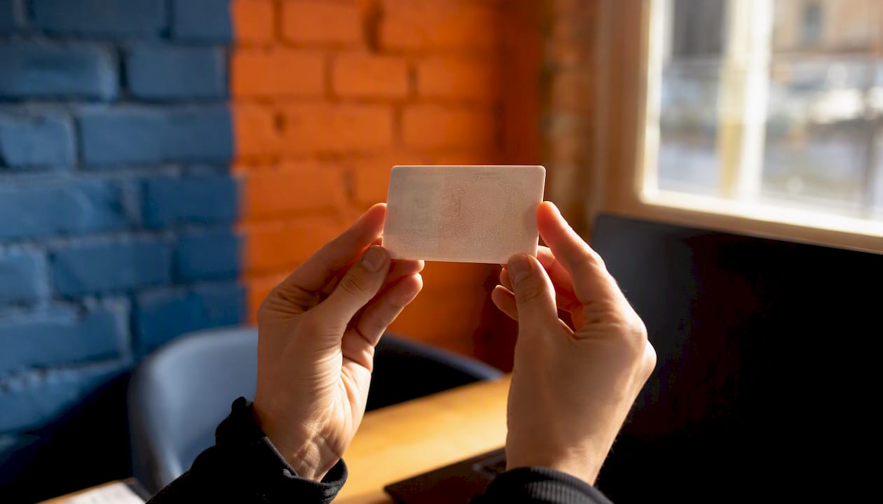 Des mains tenant une carte de permis de conduire français.