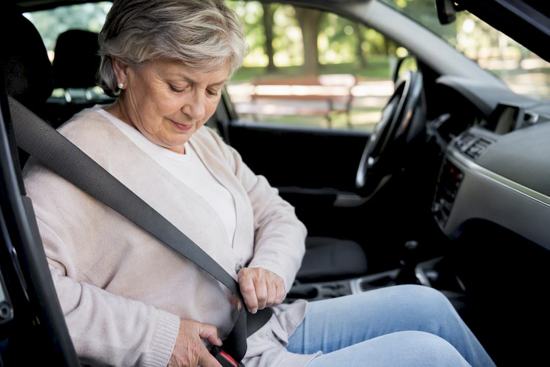 Conducteur senior attachant sa ceinture de sécurité