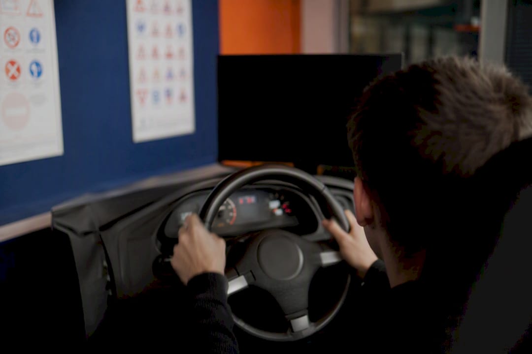 Mains sur le volant du simulateur de conduite pendant la formation