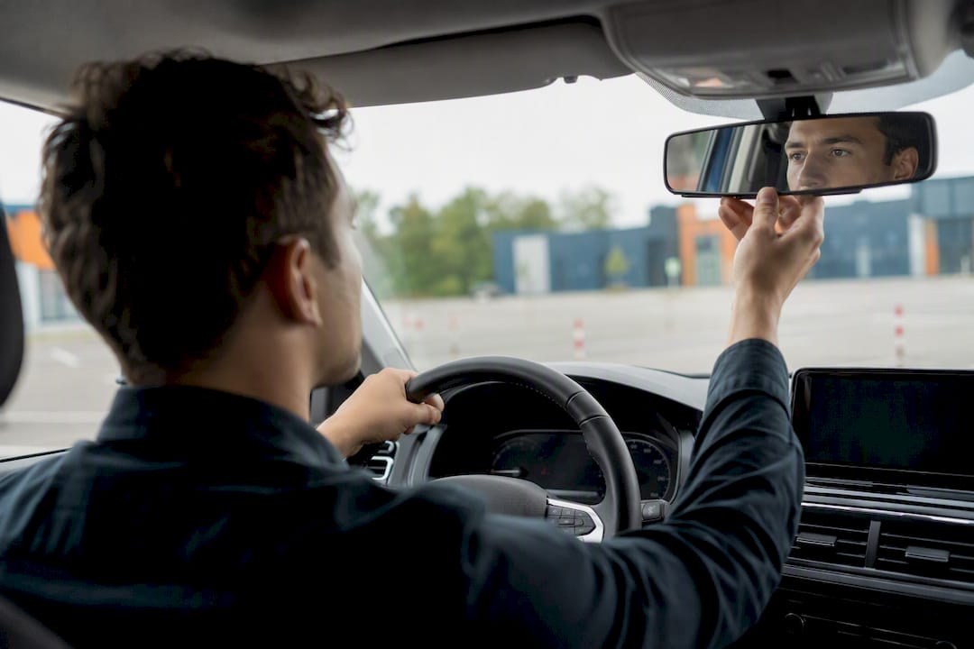 Conducteur réglant son rétroviseur pendant le stage