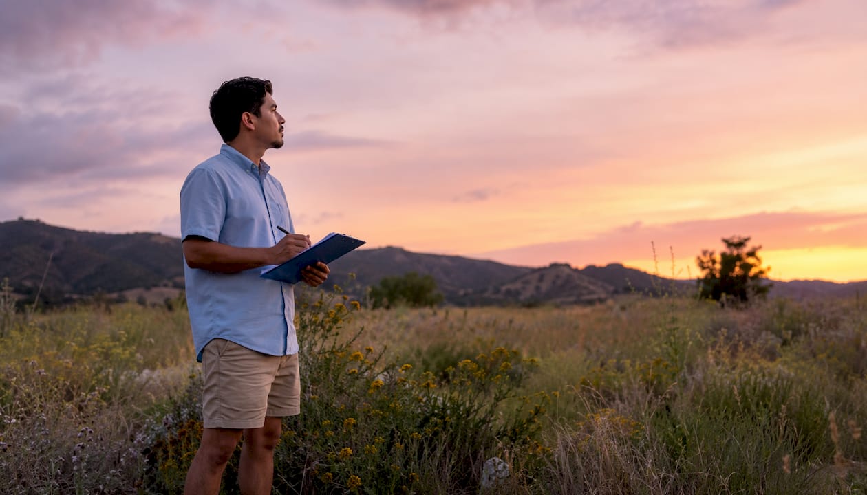 Buyer inspecting vacant land parcel outdoors