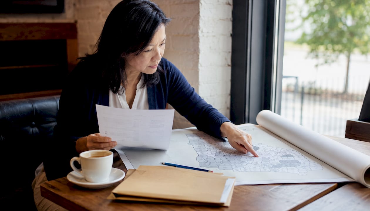 Agent reviewing property title report with Georgia map