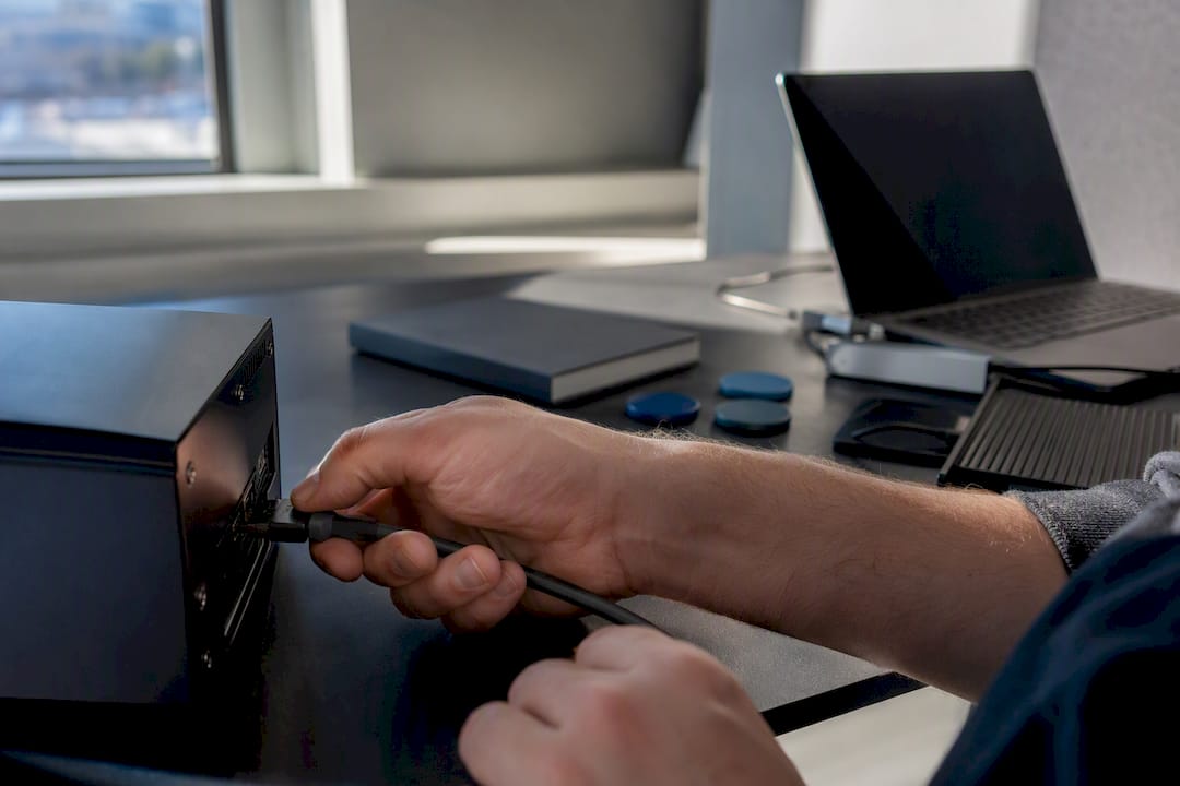 Hands connecting cable to local processing device