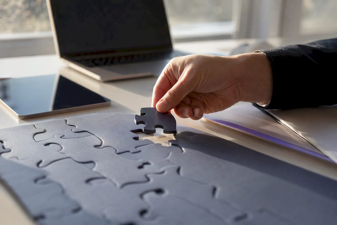 Hand placing puzzle piece symbolizing pilot automation