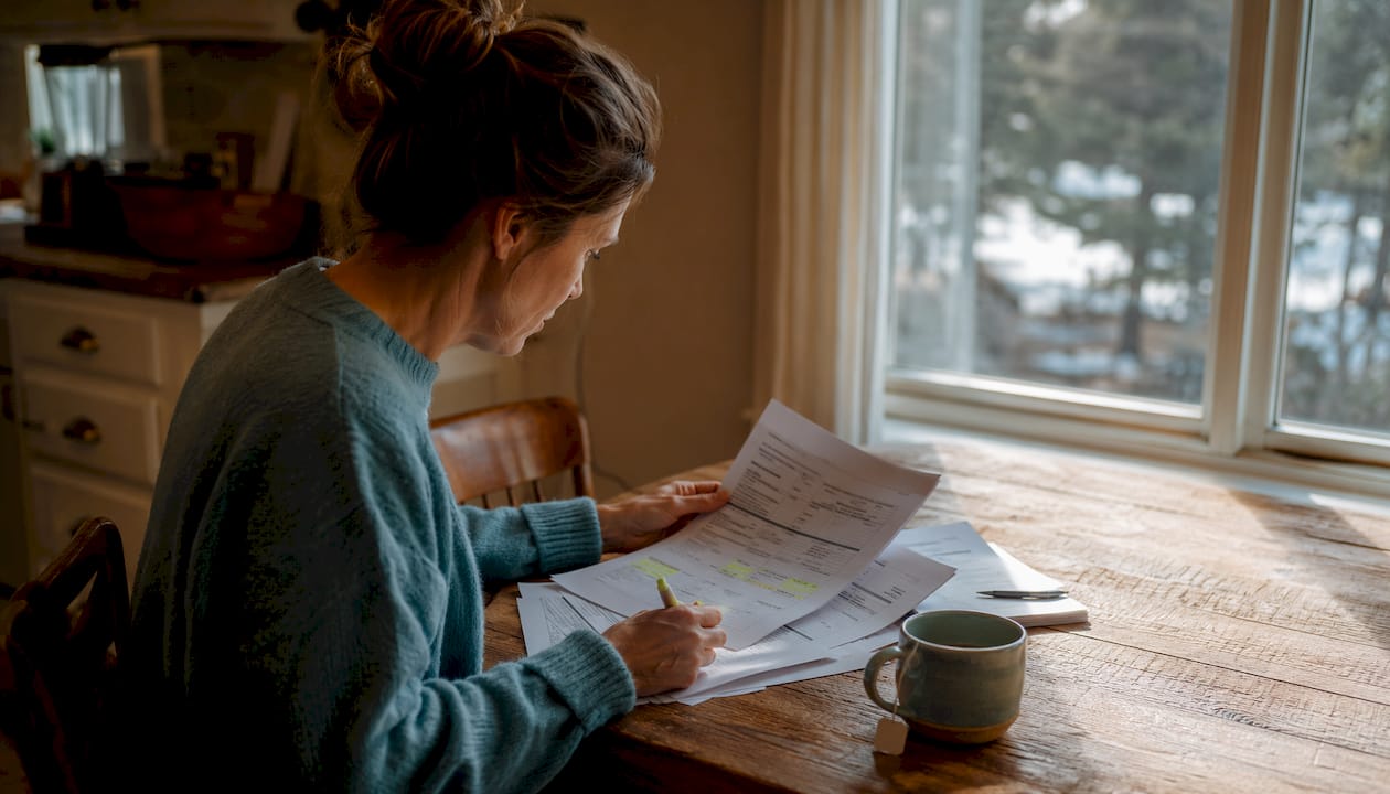 Hands examining escrow and insurance payment documents overhead view